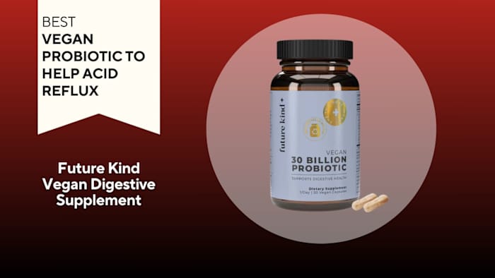 Brown pill bottle with a blue label that says "VEGAN 30 BILLION PROBIOTIC" next to two yellow capsules